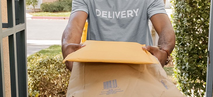 Man delivering Amazon yellow envelopes at a home front door -  pexels-kindel-media-6994119