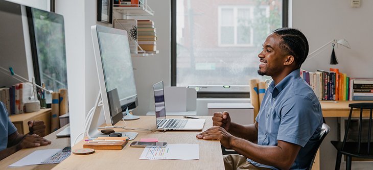 Young professional sits in front of his desktop computer as he works from his home based business -  pexels-rodnae-productions-10376169