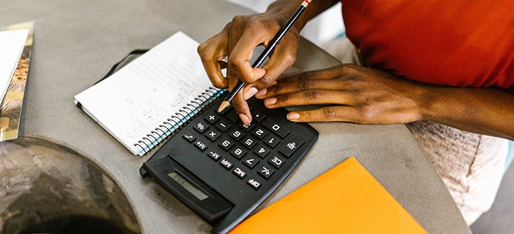 A person using a pen as a guide to read a business chart to calculate Debt Service Coverage Ratio (DSCR) -  pexels-lukas-590020