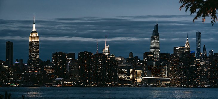 Manhattan skyline with buildings lit as Bank of America building is centered -  pexels-charles-parker-5845700